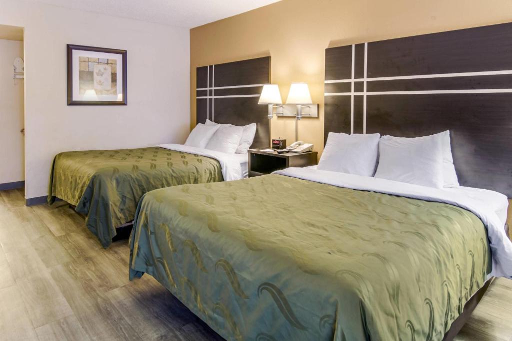 Quality Inn Stone Mountain FAQs – Spacious guest room with two queen beds, seating area, and modern amenities